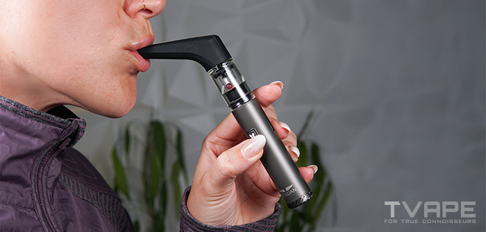 A woman is inhaling from the Utillian 6 Dab Pen