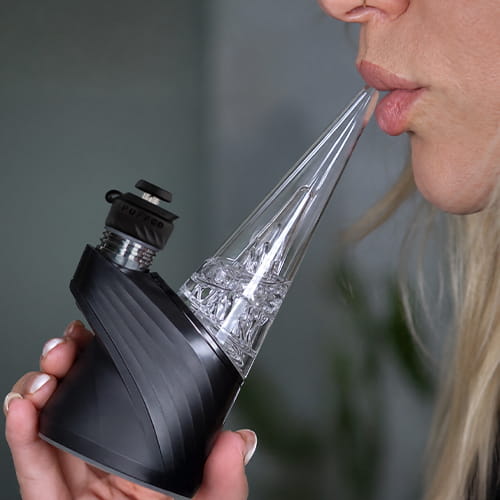 Woman inhaling from Puffco Peak Pro 3DXL with the glass mouthpiece