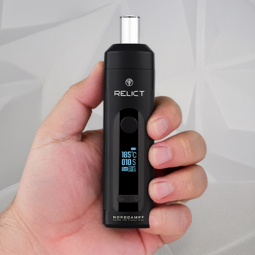 Hand holding a Norddampf Relict vaporizer.