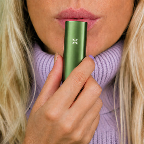 Woman in the process of using the Pax Flow vaporizer.