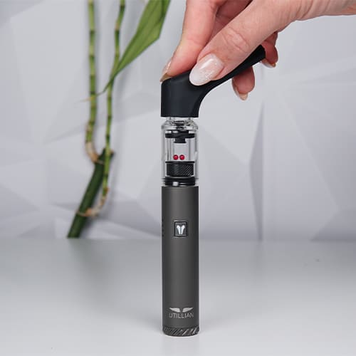 Utillian 6 dab pen on a table while woman is attatching its extended mouthpiece.