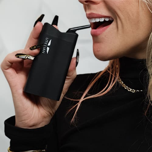 Woman in the process of using the Utillian 850 vaporizer.