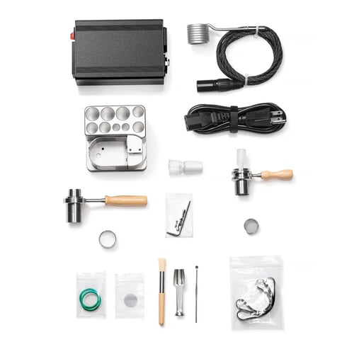 Crossing One Hit Wonder V2 kit contents laid out: PID controller, 25mm XL barrel coil, power cable, aluminum dock, wireless heater with wooden handle, Titanium Matrix Bowl, glass adapter, screens, o-rings, cleaning brush, and setup hardware.