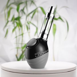 A Lookah Egg 510 thread battery placed on a white surface with a blurred green plant background.